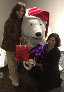 Joy and Kelly pose with a friendly polar bear and their sock donations.